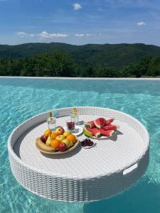 een tafel met fruit op het water bij Home Andrea with infinity salty pool in Roč