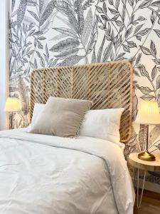 1 dormitorio con cama blanca y papel pintado con motivos florales en Terracotta, en Saint-Étienne
