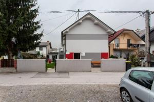 une maison blanche et rouge avec une voiture garée devant dans l'établissement Ljubljana sLOVEnia + FREEparking & Bikes, à Ljubljana