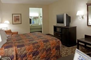 Cette chambre comprend un lit et une télévision à écran plat. dans l'établissement Americas Best Value Inn Byhalia, à Byhalia
