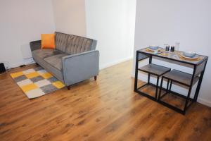 a living room with a couch and a table at Cosy Two Bedroom Apartment in London