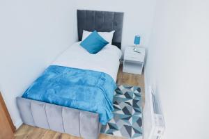 a bedroom with a bed with a blue comforter at Cosy Two Bedroom Apartment in London