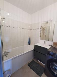 a bathroom with a tub and a sink and a bath tub at Appartement 2 personnes in Trets