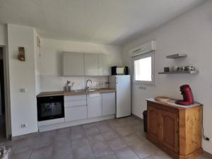 a kitchen with white cabinets and a white refrigerator at Appartement 2 personnes in Trets