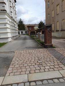 eine Kopfsteinpflasterstraße in einer Gasse zwischen Gebäuden in der Unterkunft Schöne Wohnung für Monteure und sonstige Reisende in Zwickau