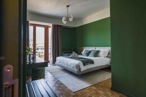 a bedroom with green walls and a bed and a window at Gaby Lake Suites in Como