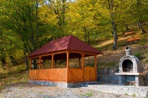 a wooden gazebo with a tower in a forest at Casa Panorama Sovata in Sovata