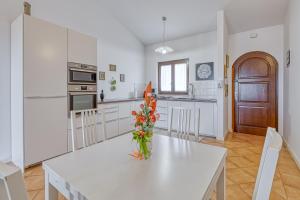een keuken met een tafel met een vaas met bloemen erop bij Pool House Kristina near Poreč - Happy Rentals in Labinci