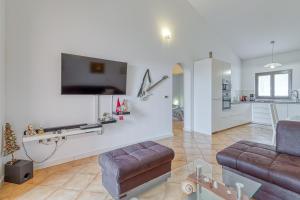 salon z kanapą i telewizorem na ścianie w obiekcie Pool House Kristina near Poreč - Happy Rentals w mieście Labinci