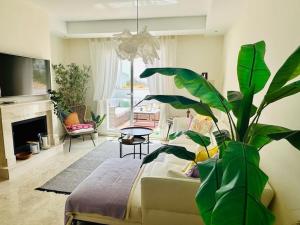 uma sala de estar com um sofá e uma planta em Superior 3BR Duplex Penthouse in Aloha em Marbella