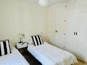 twee bedden in een kamer met witte muren en witte kasten bij Superior 3BR Duplex Penthouse in Aloha in Marbella