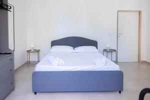 um quarto com uma cama azul e 2 toalhas brancas em Seaport #Rooms em Trani