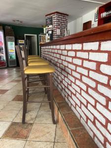a bar with two stools against a brick wall at Eagle’s Nest Hostel in Postojna