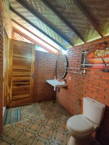 La salle de bains est pourvue de toilettes et d'un mur en briques. dans l'établissement The Lumbung Tejakula, à Tejakula