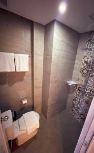 a bathroom with a toilet and a shower with towels at AJ BOUTIQUE HOTEL in Yogyakarta