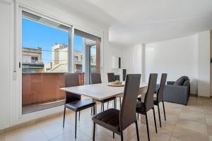 a dining room with a table and chairs and a large window at Sara in L'Aldea