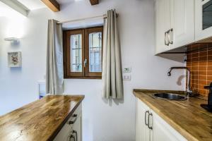 ミラノにあるSecret Navigli Suiteのキッチン(白いキャビネット、木製カウンタートップ付)