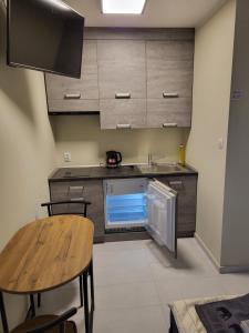 a small kitchen with a sink and a table at 7 Mila Pokoje Kutno in Kutno