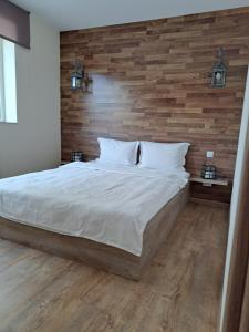 a bedroom with a large bed with a wooden wall at Todea House in Reghin