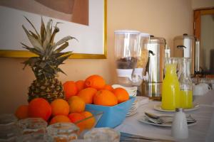 una mesa con un tazón de naranjas y una piña en Hotel Del Marques, en Vallenar