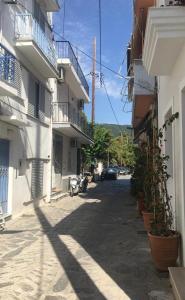 an alley between two buildings with a car parked on the street at The Captain's House in Skiathos