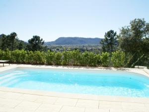 a large swimming pool with a view of a vineyard at Beautiful Villa in Vidauban with seasonal Pool in Vidauban