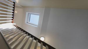 Una escalera en una habitación blanca con ventana en Coastal View House, en Buncrana