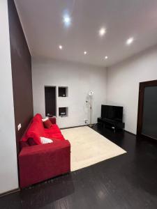 uma sala de estar com um sofá vermelho e uma televisão de ecrã plano em Rataskaevu 6 Apartment em Talin