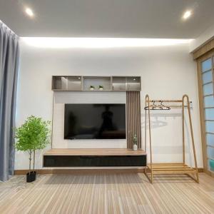 un salon avec une grande télévision à écran plat dans l'établissement M1 Homestay 8 Pax Muji Concept (Town City), à Malacca 22 autres photos