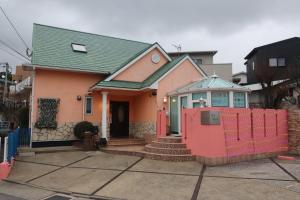 uma casa com uma cerca vermelha em frente em 1日1組限定Villa Dazaifu 露天風呂付1棟貸し em Dazaifu