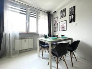 uma sala de jantar com uma mesa e cadeiras e uma janela em INFLANCKA Apartment - Self Check-In 20h em Breslávia