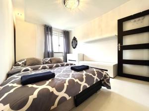 um quarto com uma cama com um edredão castanho e branco em INFLANCKA Apartment - Self Check-In 20h em Breslávia