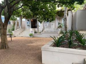 a house with a porch and stairs in front of it at Auret Street Garden Cottage in Paarl