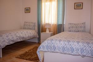 1 dormitorio con 2 camas y ventana en Casa do Mar en Salema