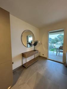 a living room with a mirror and a table at Prestige View 103 in Éze