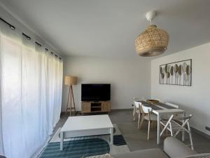 a living room with a couch and a table and a tv at Prestige View 103 in Èze