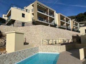 a building with a swimming pool in front of a house at Prestige View 103 in Èze