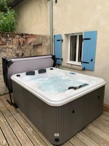 a large bath tub sitting on a wooden deck at La petite maison de Justin - Jacuzzi privatif in Bagnères-de-Bigorre