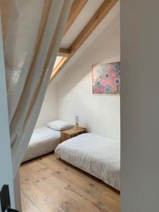 a bedroom with two beds and a painting on the wall at La petite maison de Justin - Jacuzzi privatif in Bagnères-de-Bigorre