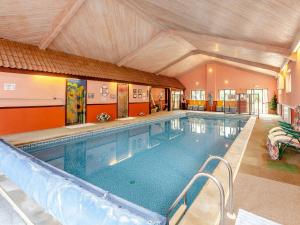 a large swimming pool with a slide in a building at Nightingale in Temple Combe