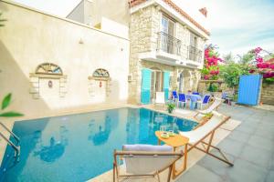 a villa with a swimming pool and a house at Alacati Asmali Konak Hotel in Alaçatı