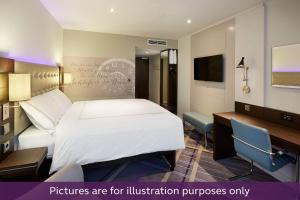 a hotel room with a large bed and a desk at Premier Inn Wuppertal City Centre in Wuppertal