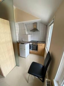 a kitchen with a black chair in a small room at Studio to let in Covent Garden with kitchen in London