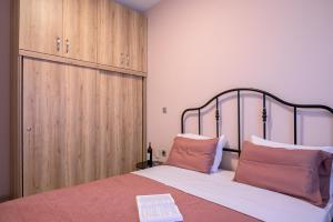 a bedroom with a bed with a wooden cabinet at Zoe's City Apartment in Alexandroupoli