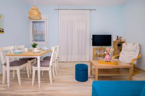 a living room with a table and chairs and a tv at Zoe's City Apartment in Alexandroupoli