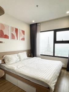1 dormitorio con 1 cama grande y ventana grande en The Charm - Vacation in Vinhome Ocean Park, en Gia Lâm Pho