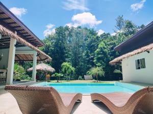 un complexe avec une piscine et deux chaises dans l'établissement Superb pool villa 5 bedrooms, à Baan Tai