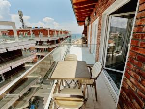una mesa y sillas en un balcón con vistas al océano en Matteo's Apartments en Velipojë
