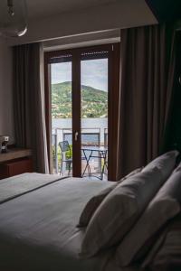 a bedroom with a bed with a view of a balcony at Gaby Lake Suites in Como
