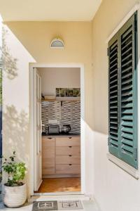 uma porta aberta para uma cozinha numa casa em Airport Garden Room em Cilipi